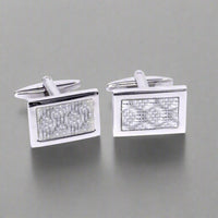 Pair of silver rectangular cufflinks with textured design on a white background