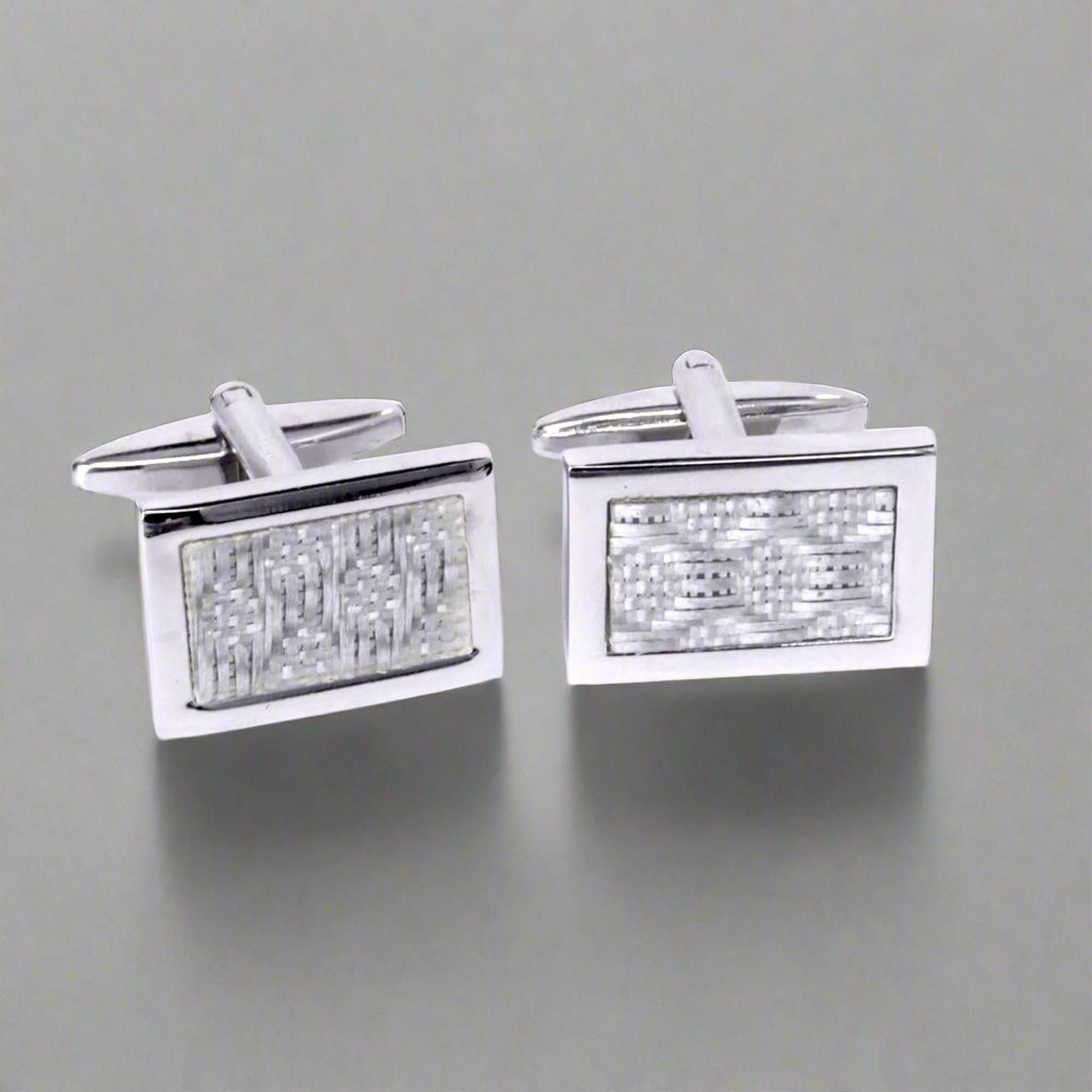Pair of silver rectangular cufflinks with textured design on a white background
