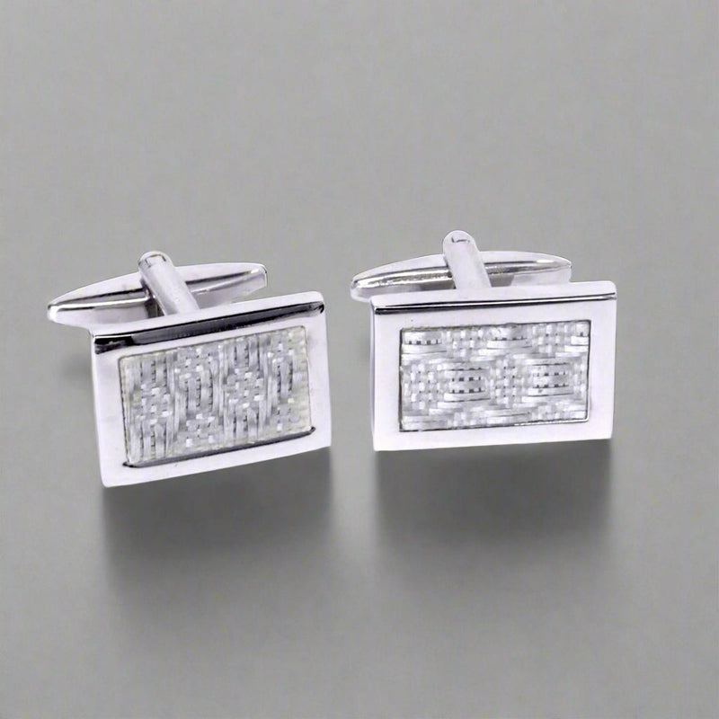Pair of silver rectangular cufflinks with textured design on a white background