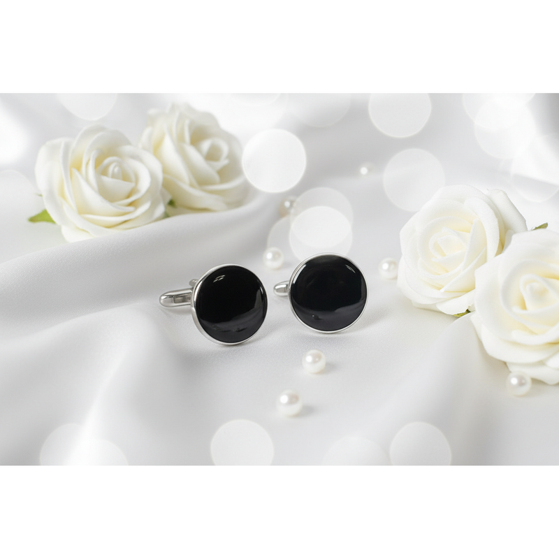 Premium black enamel cufflinks displayed elegantly with white roses and pearls.