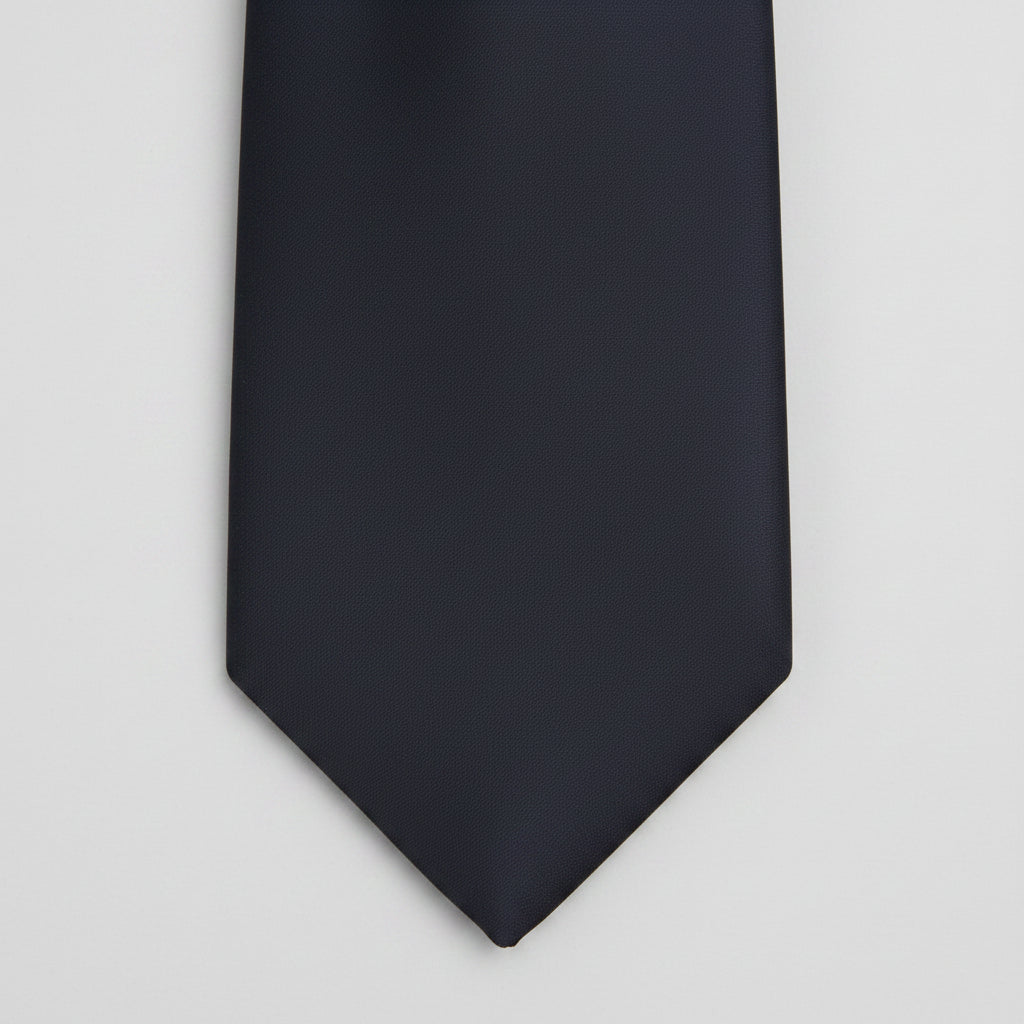 A close-up of a solid black necktie tip against a plain white background.