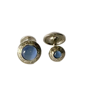 Pair of silver cufflinks with blue stones on a white background