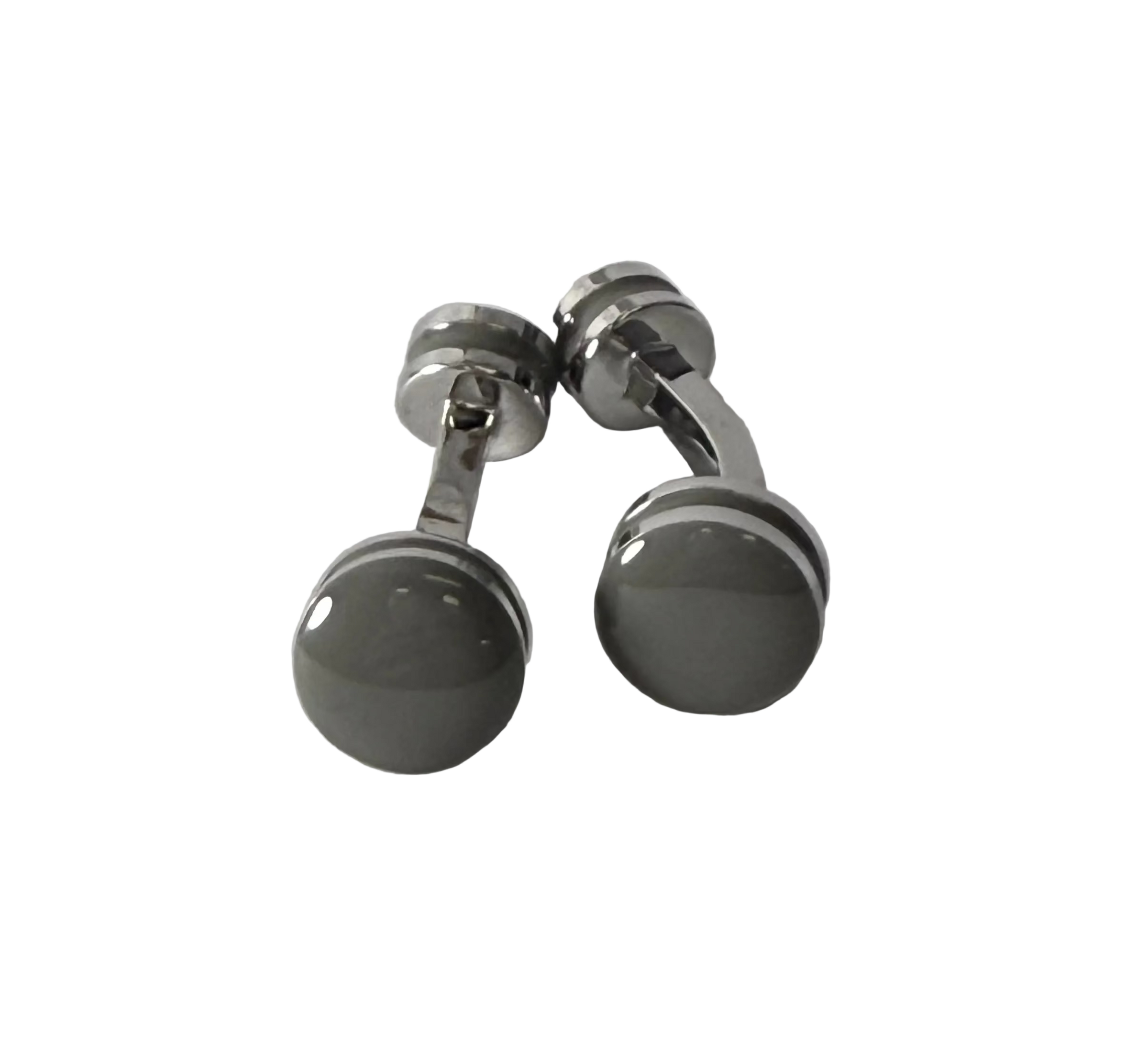 A pair of silver-toned cufflinks with round, polished dark gray to black faceted front discs, photographed on a light gray textured surface.
