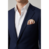 A close-up of a man wearing a navy blue suit jacket over a white dress shirt, with a patterned beige and brown pocket square in the breast pocket.