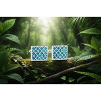 A pair of silver-tone cufflinks with turquoise enamel crack design, displayed against an outdoor backdrop.