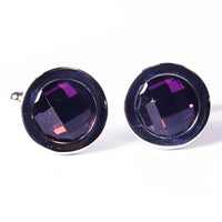 Pair of round cufflinks with purple gemstones on a white background